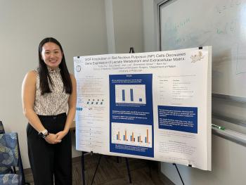Photo of Trudy Zhou in front of research poster.